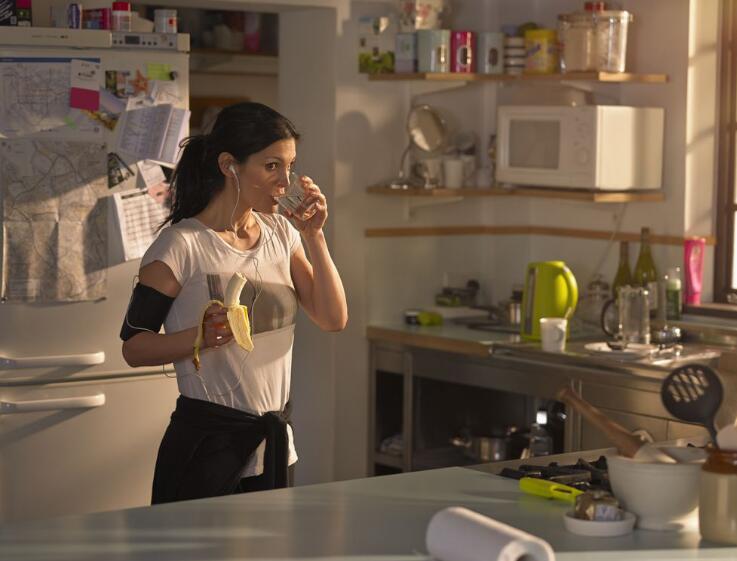 Woman in the kitchen preparing for run