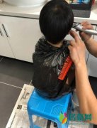 吴京在家给儿子理发 用塑料袋套住儿子身体逗趣十